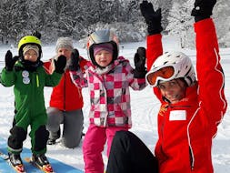Kinder und Skilehrer halten Hände in die Höhe während Kinder-Skikurs (4-14 J.) für alle Levels mit Schneesportschule Mitterdorf.