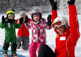 Les enfants et le moniteur de ski se tiennent la main en l'air pendant les Cours de ski pour Enfants (4-14 ans) pour Tous les Niveaux avec G&S snowsportschool Mitterdorf.
