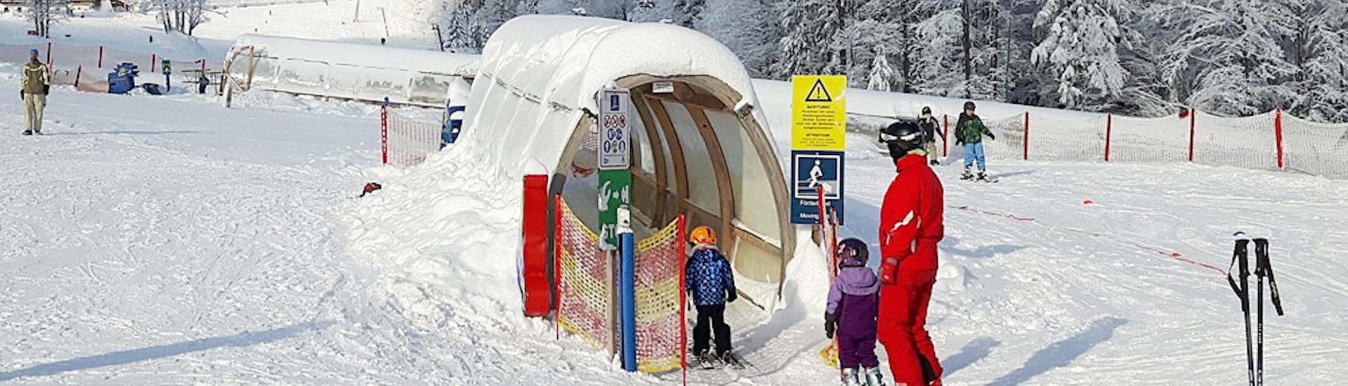 Les enfants prennent le tapis magique pendant les cours particuliers de ski pour enfants de tous niveaux de G&S snowsportschool Mitterdorf.