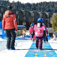 Einige Kinder versuchen, während des Kinderskikurses (3-4 J.) für Anfänger auf den Skiern zu stehen - Baby Club mit Scuola di Sci Pila.