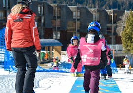 Some kids trying to stand on the skis during the Kids Ski Lessons (3-4 y.) for Beginners - Baby Club with Scuola di Sci Pila.