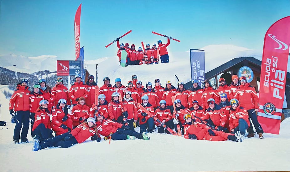 De instructeurs van Scuola di Sci Pila poseren samen voor de camera na de skilessen voor volwassenen voor alle niveaus.