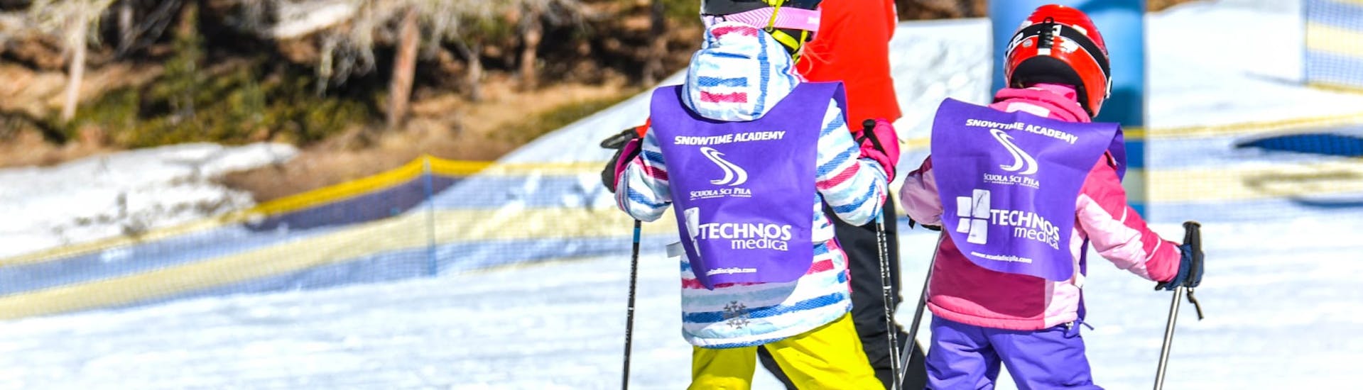 Een paar kinderen volgen hun instructeur van Scuola di Sci Pila tijdens de Privé skilessen voor kinderen (vanaf 3 jaar) van alle niveaus.