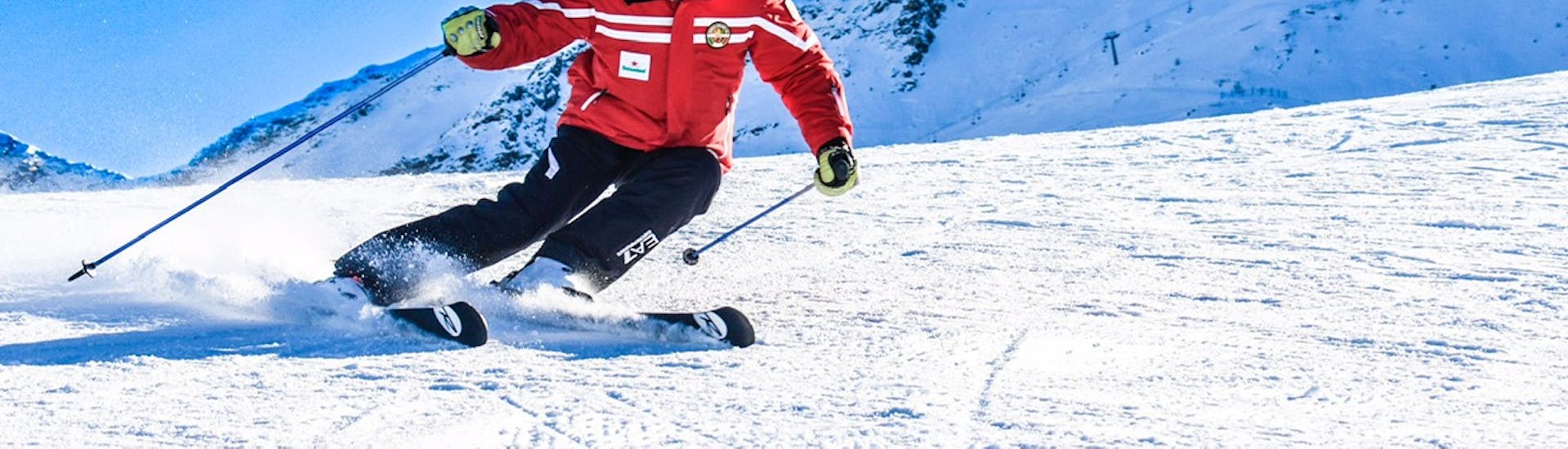 Un maestro della Scuola di Sci Pila scia durante le Lezioni private di sci per adulti per tutti i livelli.