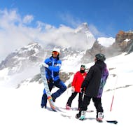 Ein Lehrer der Scuola di Sci Pila posiert vor der Kamera mit zwei Teilnehmern des Snowboard-Privatkurse für Kinder & Erwachsene für alle Levels.