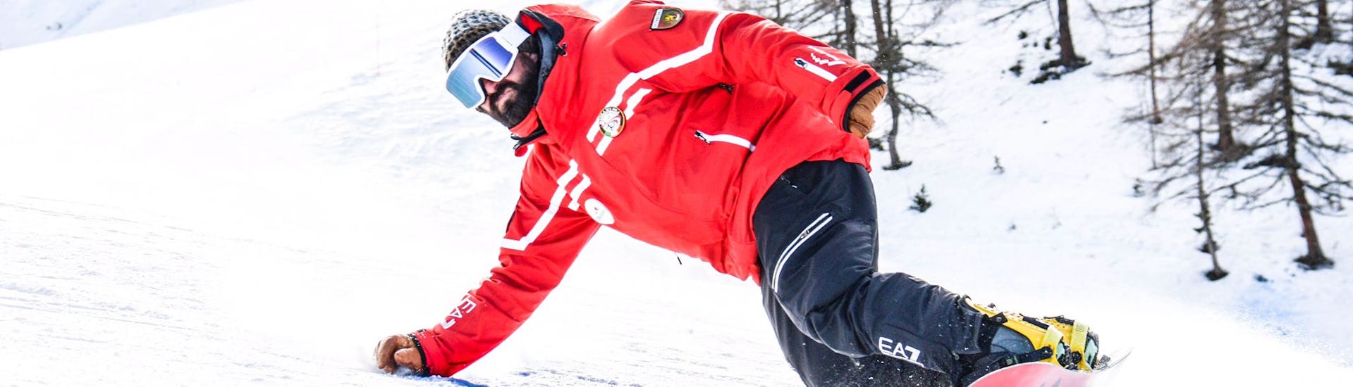 Un moniteur de la Scuola di Sci Pila fait du snowboard pendant les Cours Particuliers de Snowboard pour Enfants et Adultes de Tous Niveaux.