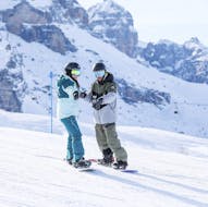 Ein Lehrer und ein Snowboarder während des Snowboard-Kurses für alle Levels mit der Scuola di Snowboard Zebra Madonna di Campiglio.