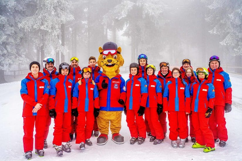 Alle Skilehrer der Skischule Sankt Englmar machen ein Foto mit dem Maskottchen Bruno beim Kinder-Skikurs (5-13 J.) für alle Levels.