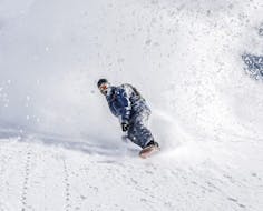 Een snowboarder leert diepe sneeuw rijden in het terrein tijdens de privélessen snowboarden voor kinderen & volwassenen van alle niveaus bij Skischool Sankt Englmar.