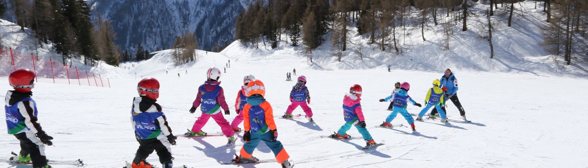 Eine Gruppe von Kindern fährt während des Kinderskikurses (3-4 J.) für Anfänger mit der Scuola Sci e Snowboard Val di Pejo.