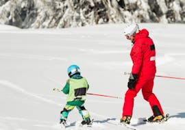 A kid is following his instructor from Promescaiol Ski & Snow Academy Daolasa during the Private Ski Lessons for Kids (from 3 y.) of All Levels.