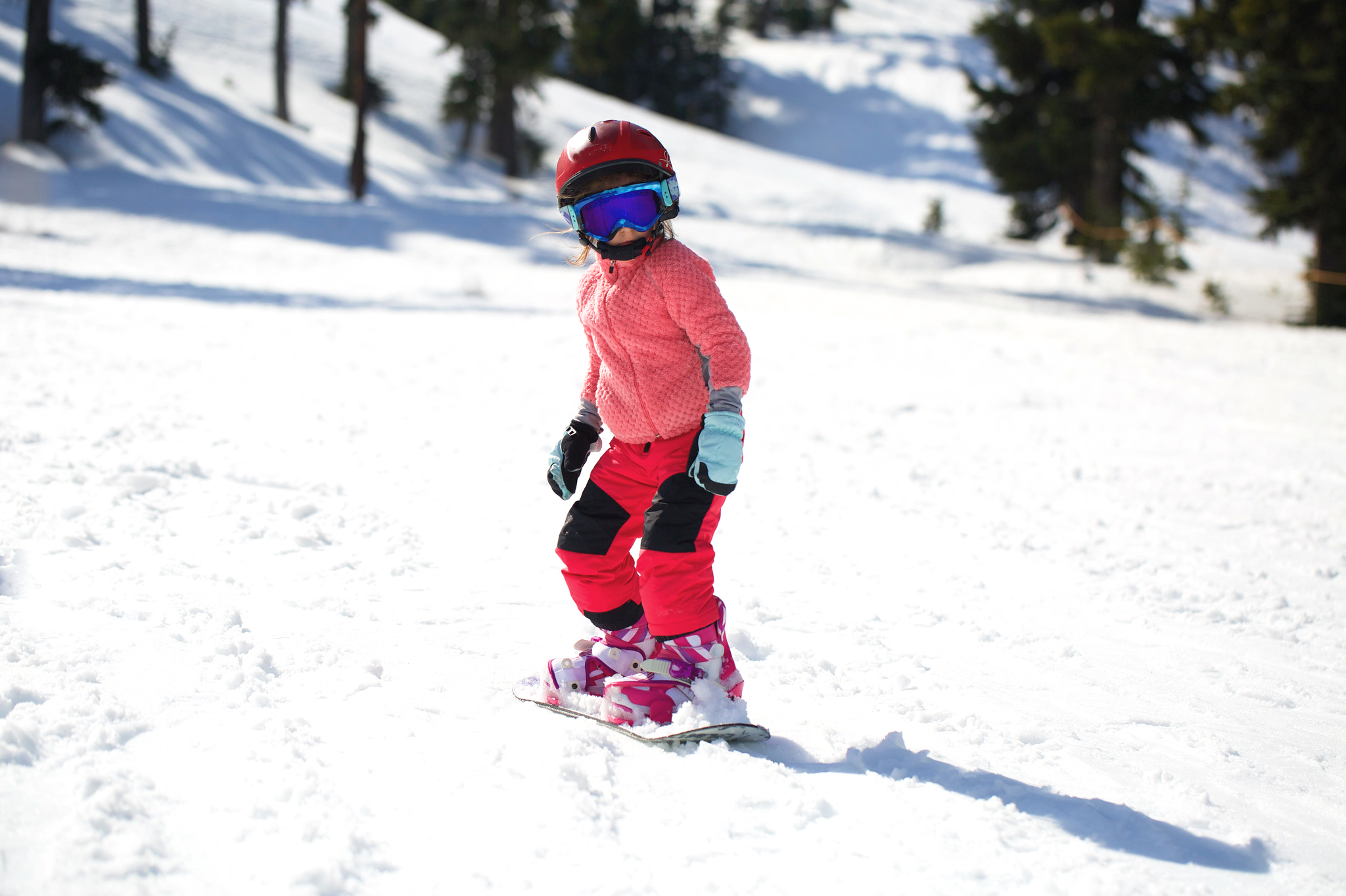 A kid doing her first descent during the Private Snowboarding Lessons for Kids (from 3 y.) & Adults of All Levels with Promescaiol Ski & Snow Academy Daolasa.