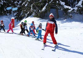 Kinderen skiën achter hun leraar tijdens de Kids Ski Lessen (3-12 j.) voor alle niveaus bij ESF La Tania.
