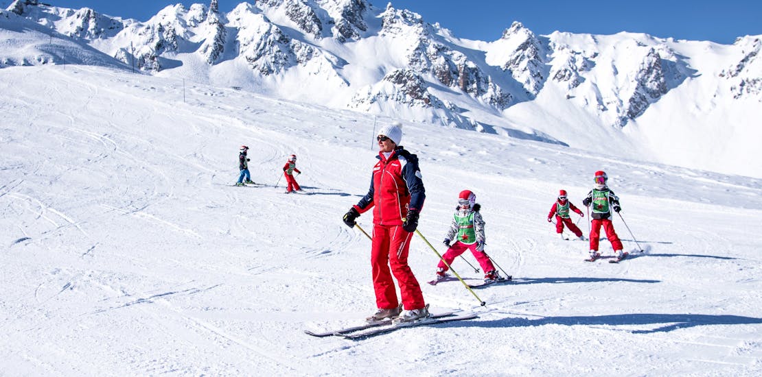 Kinderen skiën met hun instructeur tijdens hun Kids Ski Lessen "Max 7" (4-12 j.) bij ESF La Tania.