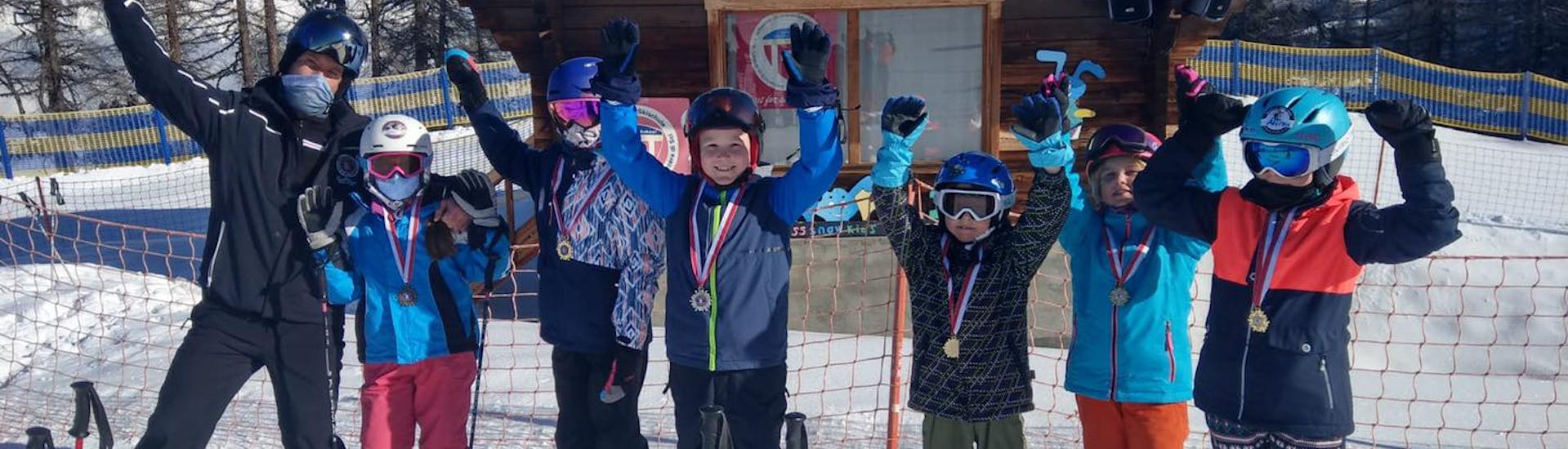 Een groep skiërs viert de grote successen bij de skilessen voor kinderen (4-15 jaar) voor beginners met Skischule Grächen - Zenklusen Sport.