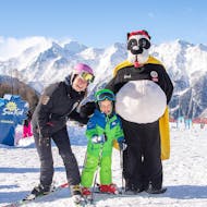 Kinderen vermaken zich met de mascotte Bobi bij de skilessen voor kinderen (4-15 j.) voor beginners met Skischule Grächen - Zenklusen Sport.