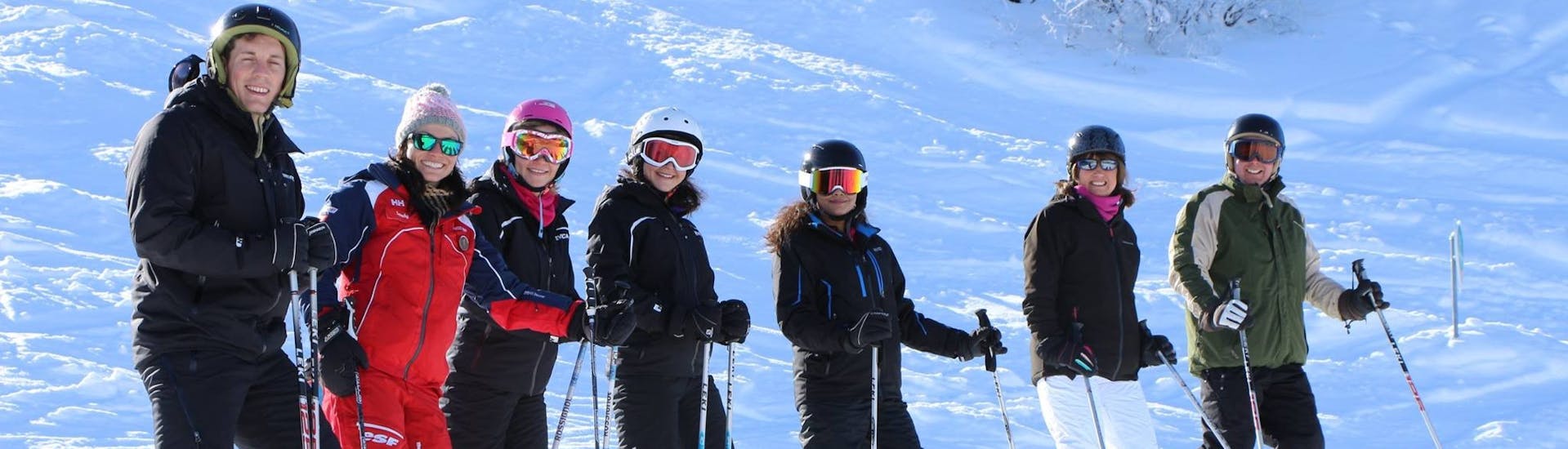 Skiërs staan in de rij voor een foto tijdens hun volwassen skilessen (vanaf 13 jaar) voor alle niveaus bij ESF La Tania.