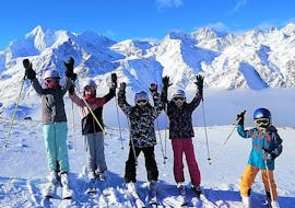 Eine Gruppe an jungen Skifahrern genießen das schöne Wetter beim Kinder-Skikurs (4-15 J.) für Anfänger mit Skischule Grächen - Zenklusen Sport.