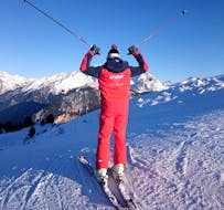 Een instructeur van de ESF La Tania staat op de top van een berg tijdens privé skilessen voor volwassenen van alle niveaus.