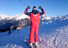 An instructor of the ESF La Tania is standing at the top of a mountain during Private Ski Lessons for Adults of All Levels.