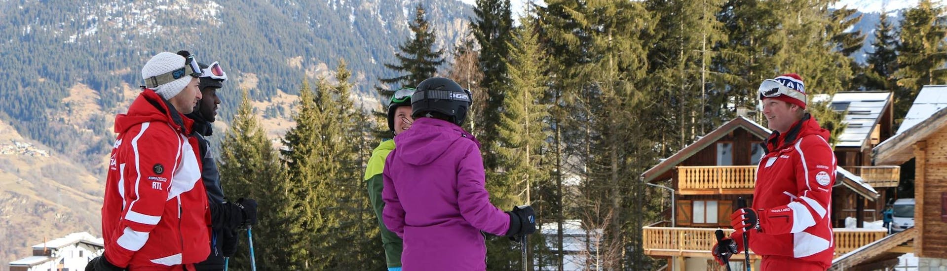 Skiërs luisteren naar de instructies van hun instructeur tijdens hun privé skilessen voor volwassenen van alle niveaus bij ESF La Tania.