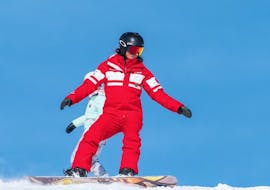 An instructor of the ESF La Tania is showing the right stande during Private Snowboarding Lessons for All Levels.