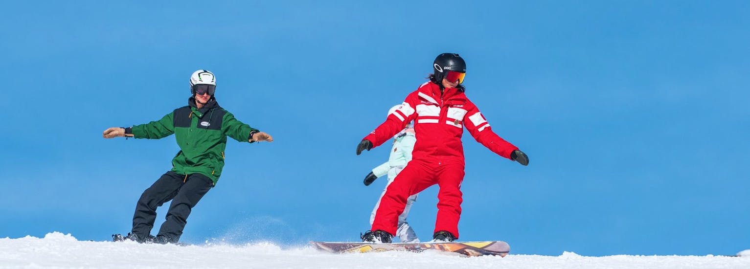 Snowboarders maken de juiste gebaren tijdens de privélessen snowboarden voor alle niveaus bij ESF La Tania.