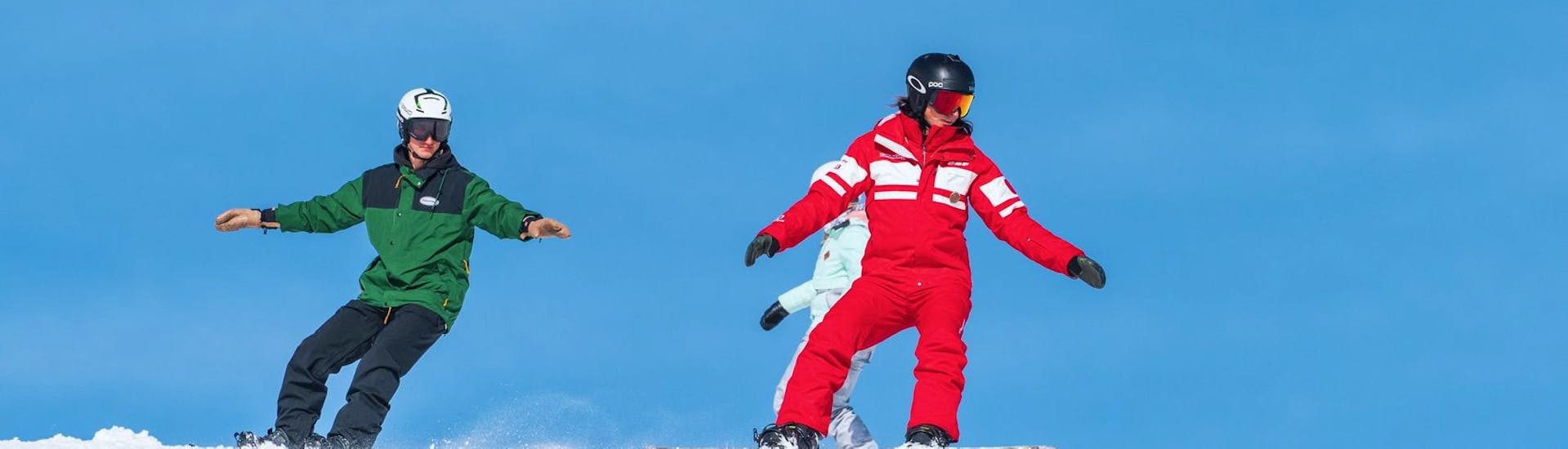 Des snowboardeurs reproduisent les bons gestes pendant un Cours particulier de snowboard pour Tous niveaux avec ESF La Tania.
