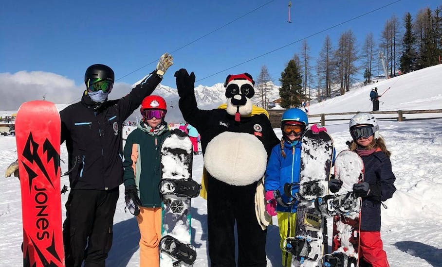 A group of snowboarders have fun at the Private Snowboarding Lessons for Kids & Adults (from 4 y.) of All Levels with Skischule Grächen - Zenklusen Sport.