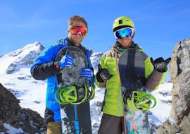 Un snowboardeur se tient au côté de son moniteur pendant son Cours particulier de snowboard avec Prosneige Val Thorens & Les Menuires.