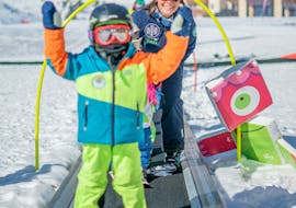 A kid takes the magic carpet during their Kids Ski Lessons "Petit Ours" (3-4 years) - Max 6 per group with Prosneige Méribel.