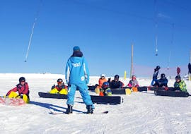 Students are listening attentively to their instructor during their Snowboarding Lessons for Kids & Adults of All Levels with ESI Grand Massif.
