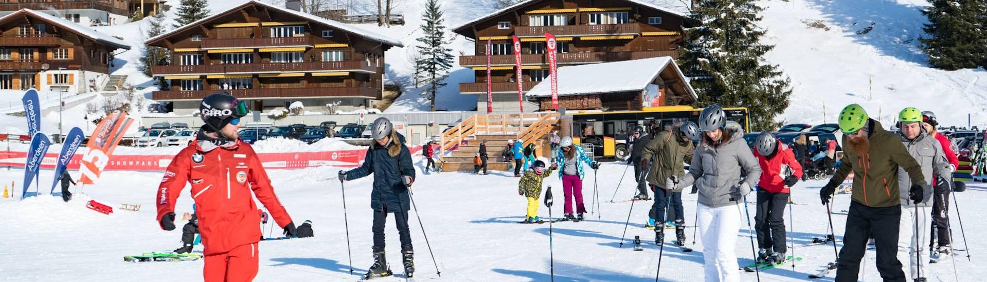 Ein Skilehrer zeigt seiner Gruppe die richtige Technik beim Skikurs für Erwachsene + Skiverleih & Transfer von Interlaken mit der Schweizer Skischule Grindlwald.