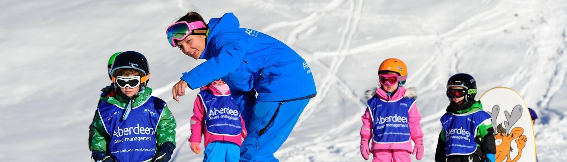 A ski instructor shows a child the correct technique at the kids ski lessons "Polar Bears" (3-5 yrs) for all levels with the Altitude Ski School Zermatt.