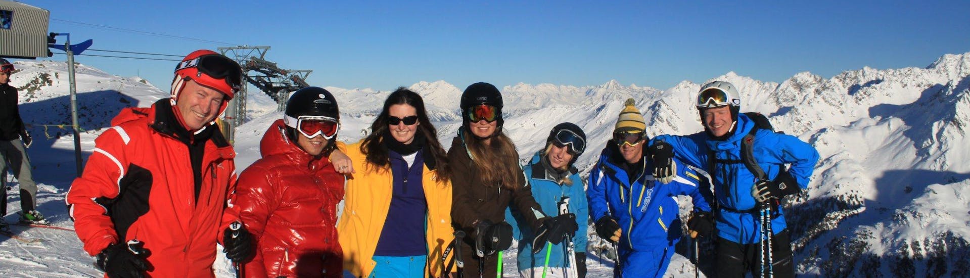A group at the adult ski lessons for all levels with Altitude Ski School Zermatt take a photo on a sunny day in Zermatt.
