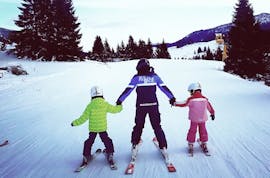 Un istruttore con dei bambini durante le Lezioni private di sci per bambini per tutti i livelli (dai 3 anni e mezzo).