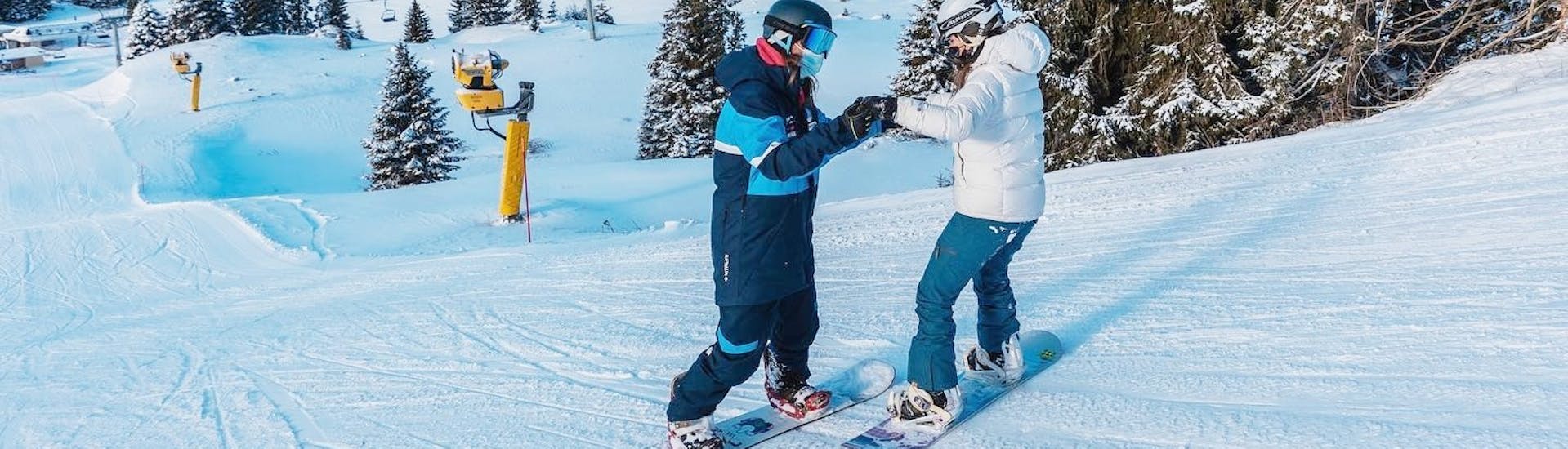 An instructor with a snowboarder during the Private Snowboarding Lessons for Kids & Adults of All Levels.