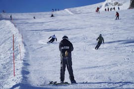 Un instructor de esquí examina las habilidades de esquí de los participantes durante las clases privadas de esquí para adultos de todos los niveles en Verbier.