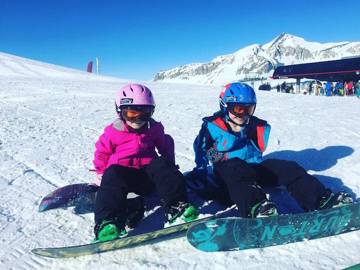2 niños divirtiéndose en la nieve durante las clases particulares de snowboard para niños y adultos de todos los niveles con PDS Snowsport - Escuela de esquí y snowboard en Verbier.