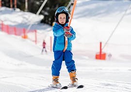 A kid takes a baby ski lift during the Kids Ski Lessons (3-4 y.) for First-Timers - Ski Start with Scuola di Sci Val di Sole.