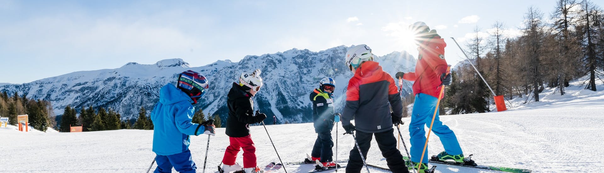 Alcuni bambini ascoltano il loro maestro della Scuola di Sci Val di Sole durante le Lezioni di sci per bambini (5-14 anni) per tutti i livelli - Junior Fun.