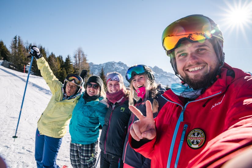 Some participants are posing in front ot the camera with an instructor from Scuola di Sci Val di Sole during the Adult Ski Lessons for All Levels (from 15 y.).