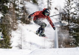 Due participanti si divertono durante le Lezioni di snowboard per tutte le età e i livelli (dai 6 anni) con Scuola di Sci Val di Sole.