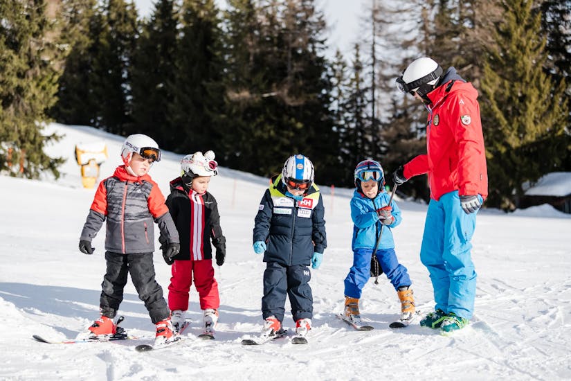 Un gruppo di bambini ascolta un maestro della Scuola di Sci Val di Sole durante le Lezioni di sci per bambini (5-14 anni) per tutti i livelli - Junior Fun Special.