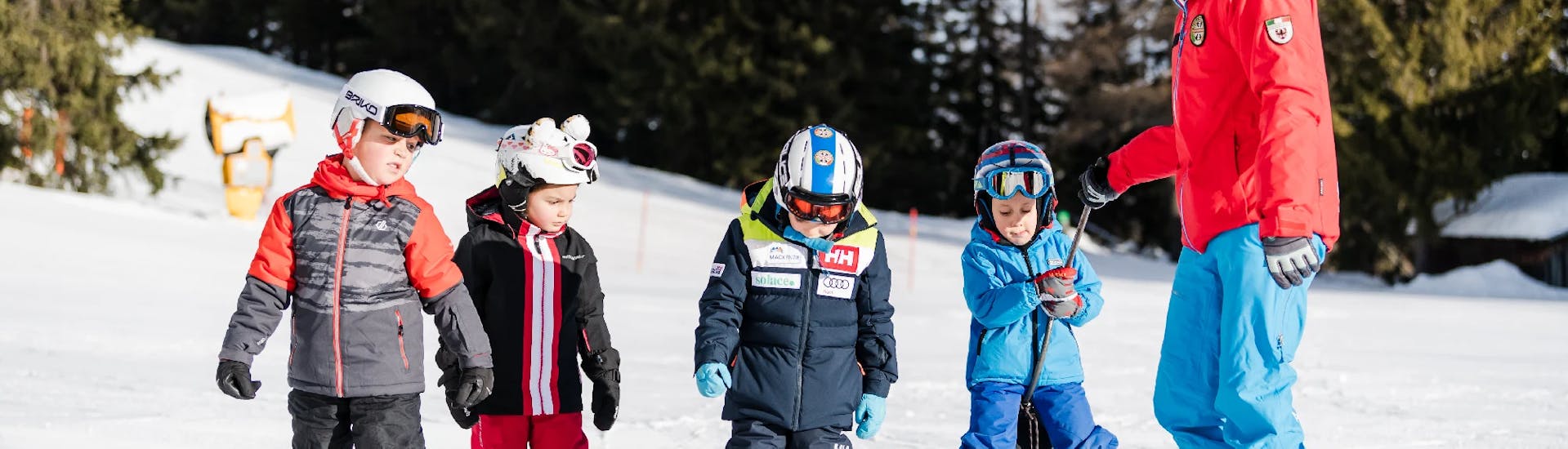 Un gruppo di bambini ascolta un maestro della Scuola di Sci Val di Sole durante le Lezioni di sci per bambini (5-14 anni) per tutti i livelli - Junior Fun Special.