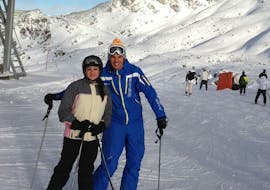 Une femme et son moniteur pendant ses leçons de ski privées pour adultes de tous niveaux à Andermatt avec Altitude Ski School Verbier & Gstaad.