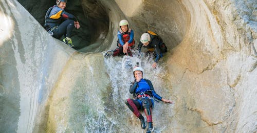 Canyoning avventuroso nella gola dello Chli Schliere con Outdoor Svizzera SA Dei partecipanti su uno scivolo naturale durante il canyoning avventuroso nella gola dello Chli Schliere con Outdoor Svizzera AG.