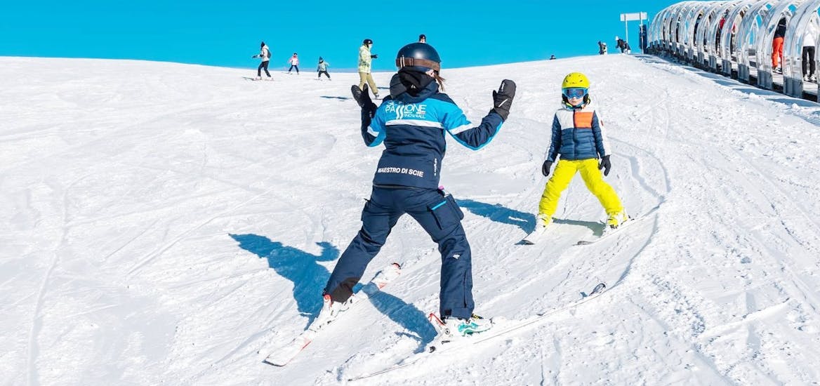 Un istruttore e un bambino durante le Lezioni private di sci per bambini per tutti i livelli (dai 3 anni e mezzo) con Scuola Sci Scie di Passione Folgaria.
