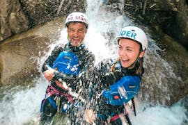Deux personnes se tiennent dans une chute d'eau pendant le Canyoning dans le canyon de Grimsel pour les Courageux avec Outdoor Switzerland AG.