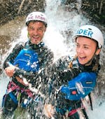 Zwei Menschen stehen in einem Wasserfall während des Canyoning in der Grimsel Schlucht für Mutige mit Outdoor Switzerland AG.